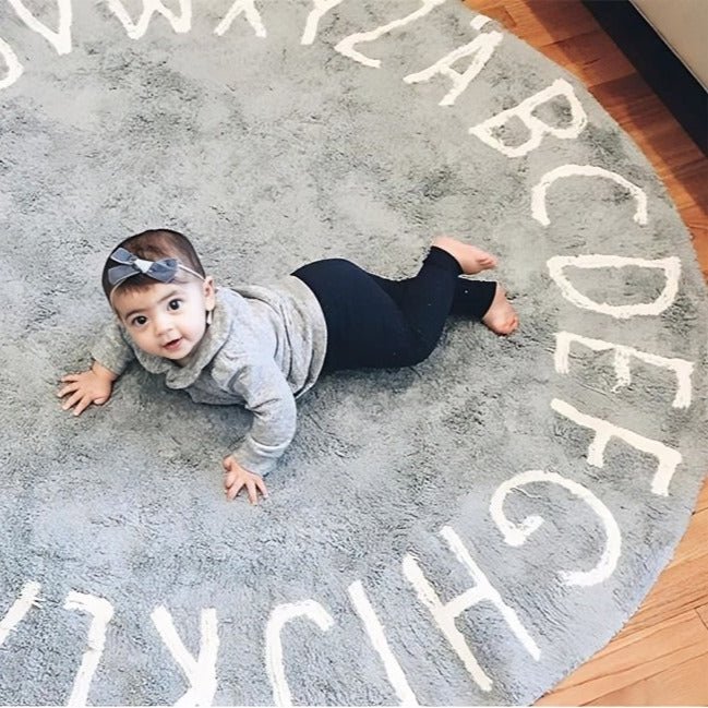 Tapis chambre bébé Alphabet Ring déployé au sol avec toutes les lettres de l’alphabet visibles, dans une chambre d’enfant lumineuse.