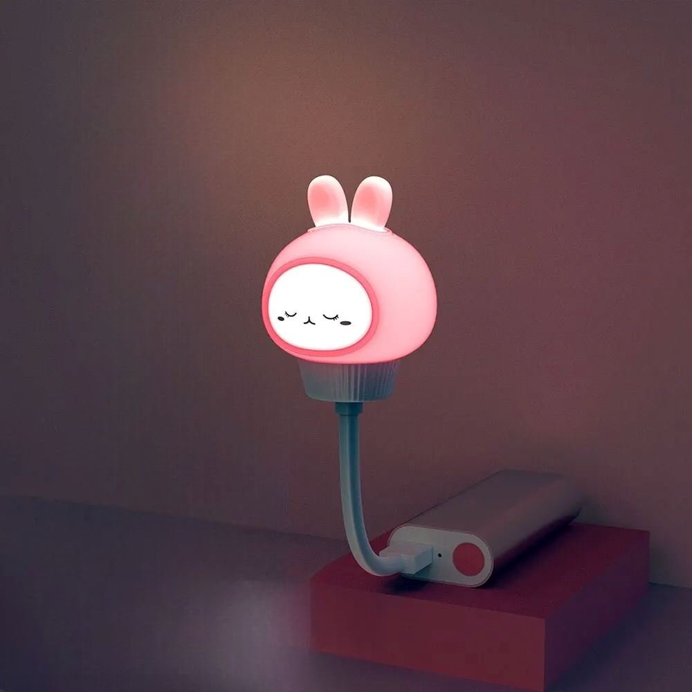 Enfant endormi à côté de la veilleuse SweetDream™ allumée, créant une ambiance apaisante.
