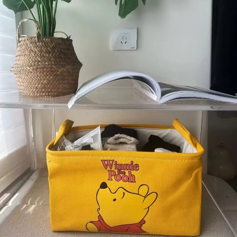 Vue rapprochée du motif Winnie l’Ourson sur boîte de rangement tissu"