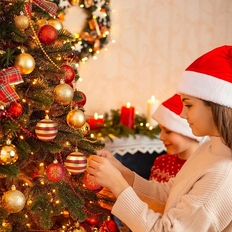 Enfants décorant un sapin avec les Boules Christmas Éclat Royal™, décoration rouge et or pour Noël.