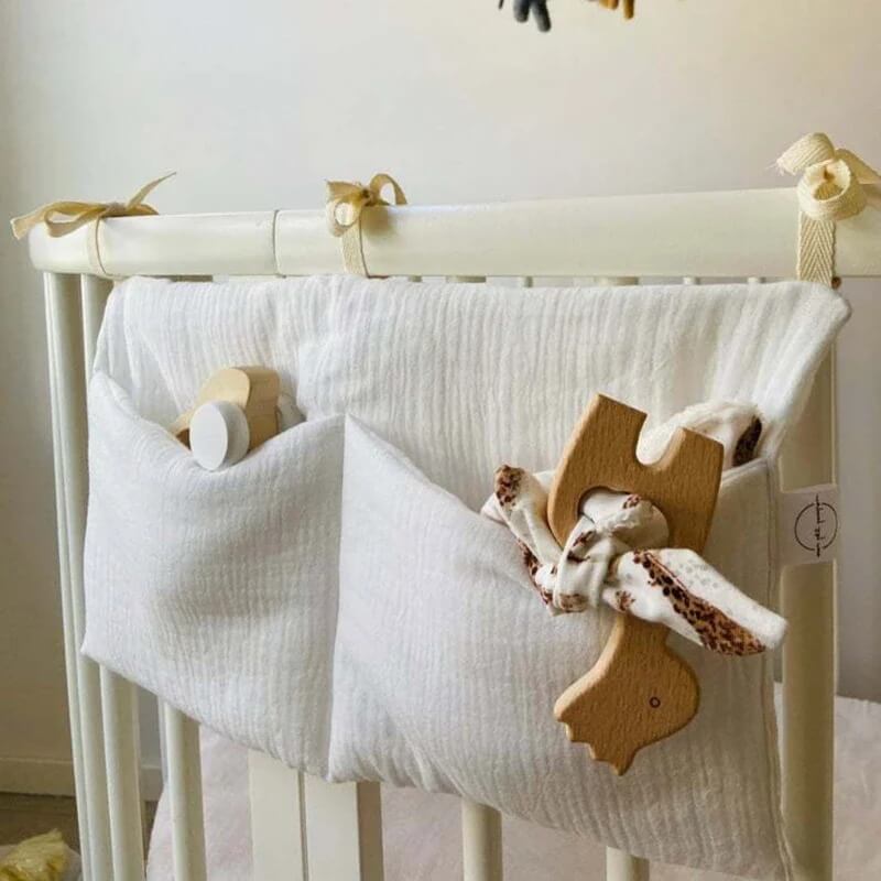 Pochette de rangement bébé suspendue avec jouets et doudou à l’intérieur