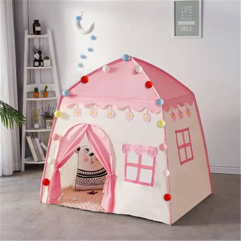Tipi enfant rose avec rideaux ouverts et coussin ours en peluche à l'intérieur
