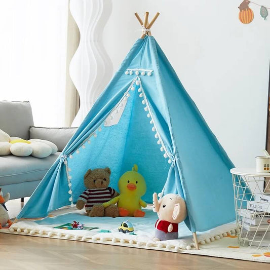 Tipi pour enfant en tissu bleu ciel avec décorations douces, peluches et coussins, installé dans une chambre lumineuse