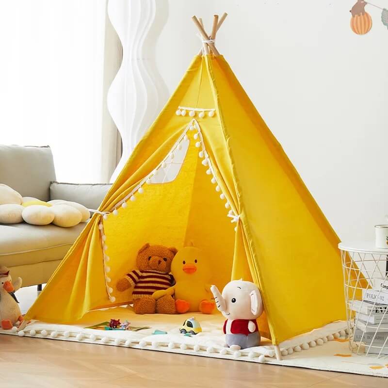 Tente tipi jaune installée dans une chambre d’enfant moderne et cosy