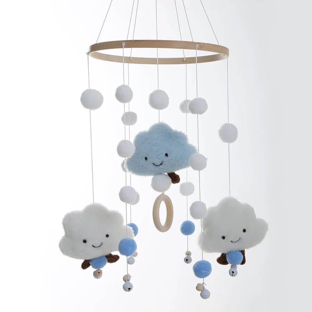 Mobile bébé PetitNuage suspendu au-dessus d’un berceau en bois dans une chambre lumineuse.