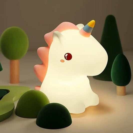 Veilleuse bébé licorne allumée, posée sur une table de chevet, diffusant une lumière douce idéale pour apaiser les enfants la nuit.