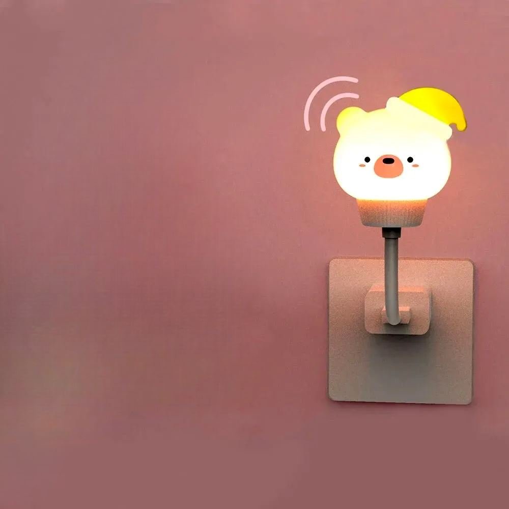 Veilleuse bébé SweetDream™ en forme d'ours diffusant une lumière douce dans une chambre d'enfant.