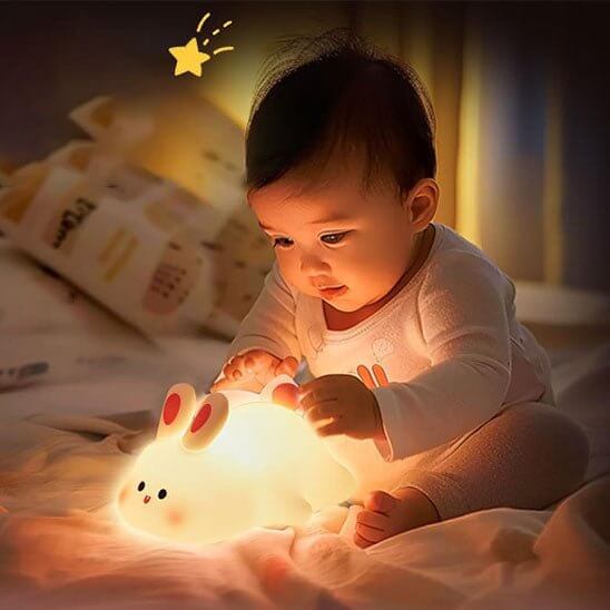 Photo montrant la veilleuse lapin allumée dans une chambre d'enfant, créant une ambiance apaisante pour le coucher