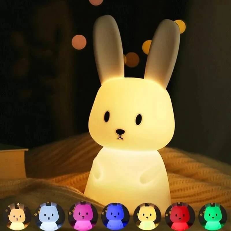 Enfant activant le changement de couleur tactile de la veilleuse LumiLapin.
