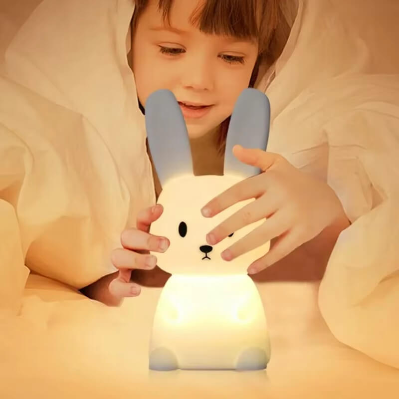 Enfant manipulant la veilleuse lapin LumiLapin en silicone souple, sans danger.